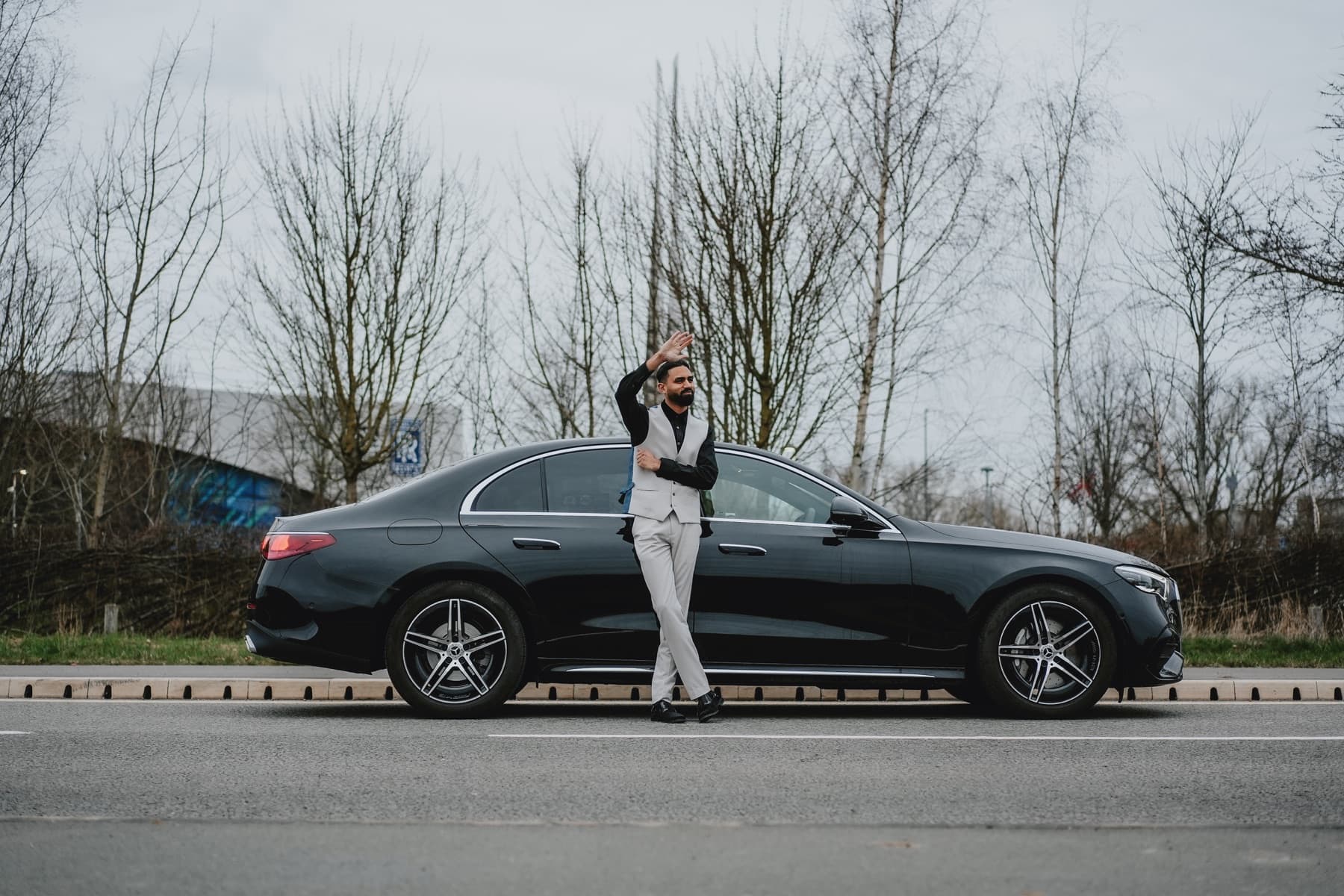 An Albatross chauffeur beside a Mercedes-Benz E-Class